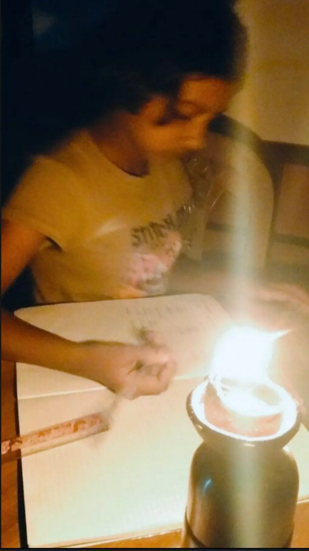 විදුලිය නොවති අවස්ථාවක දැරියක් පහනක ආලෝකයෙන් අද්යාපන කටයුතු කරන ආකාරය මෙහි දැක්වේ.