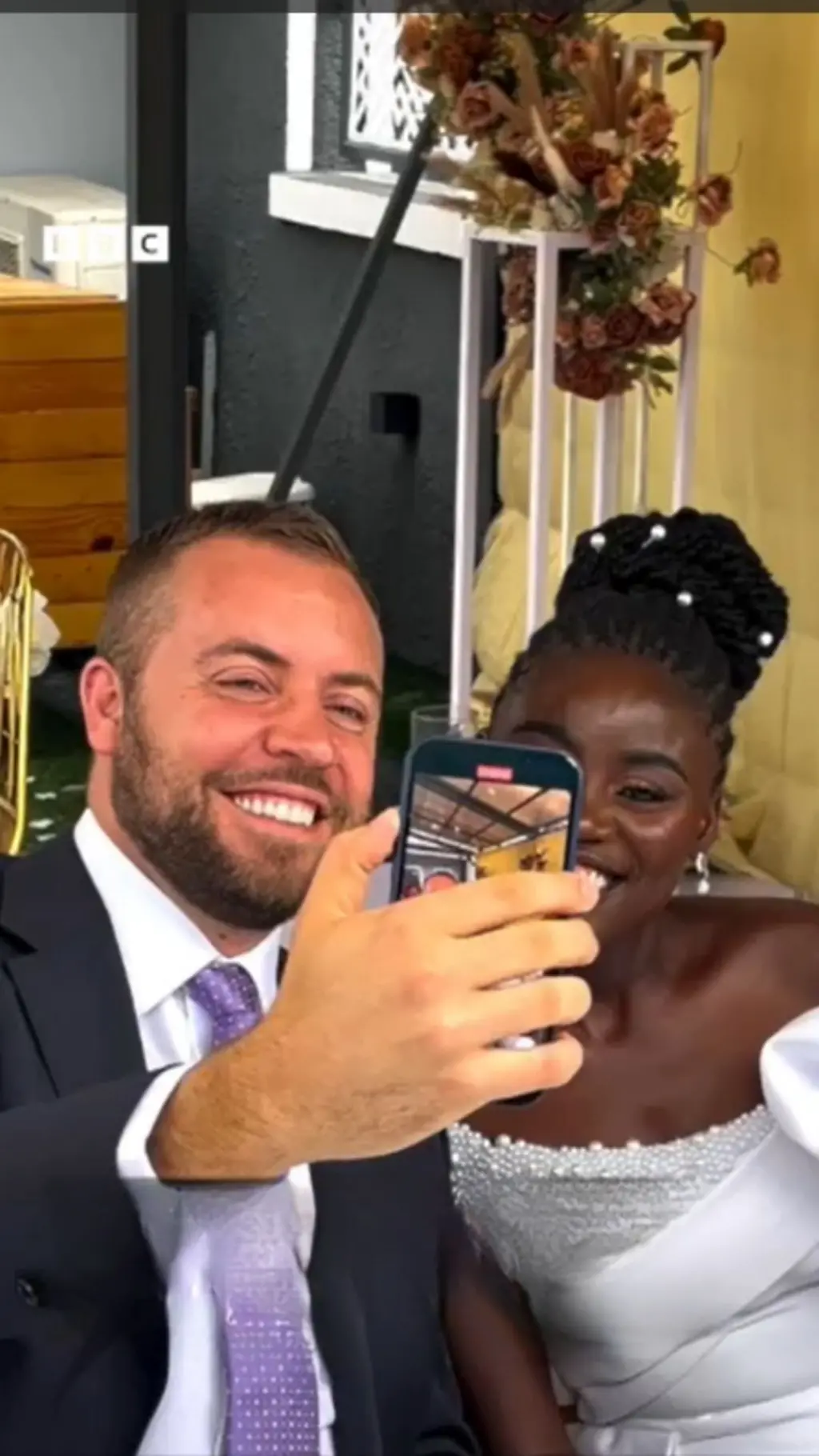 Man hold phone for selfie wit woman wey wear white