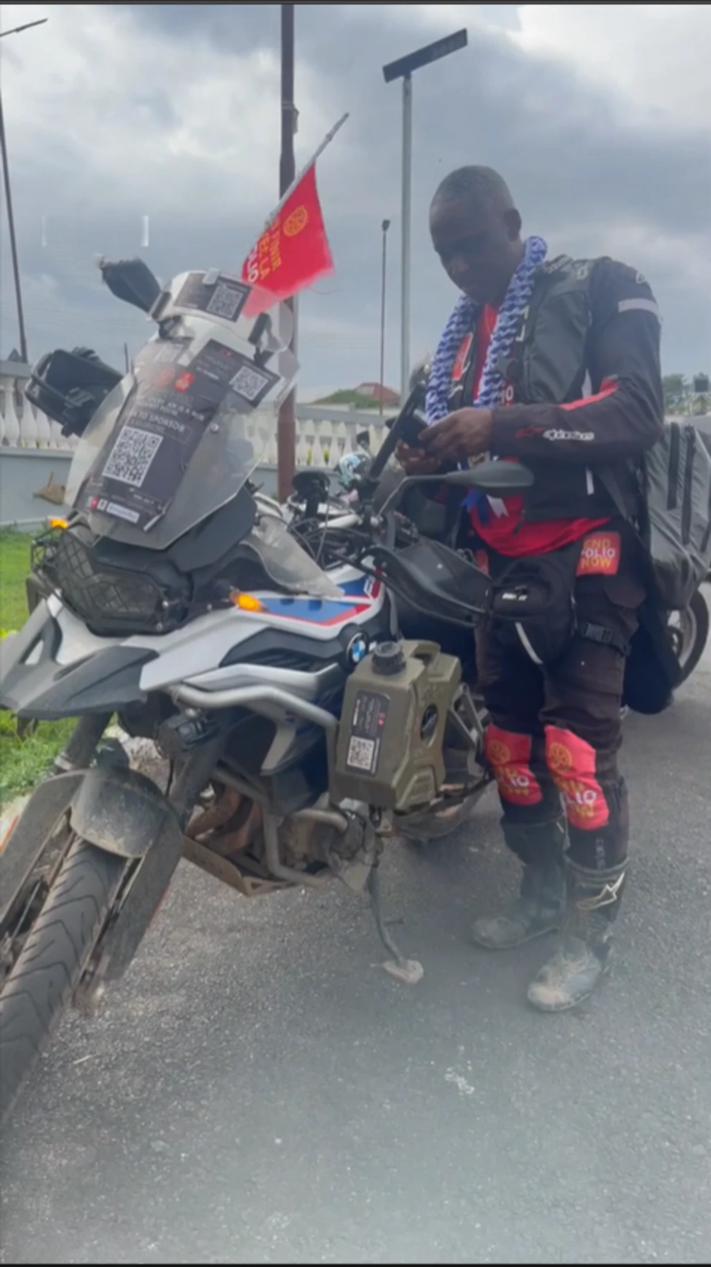 Olatunji Okedeyi duro lẹgbẹ alupupu rẹ, o wo asọ dudu alamutan lati oke delẹ, o n wo nkan lori ẹrọ alagbeka rẹ