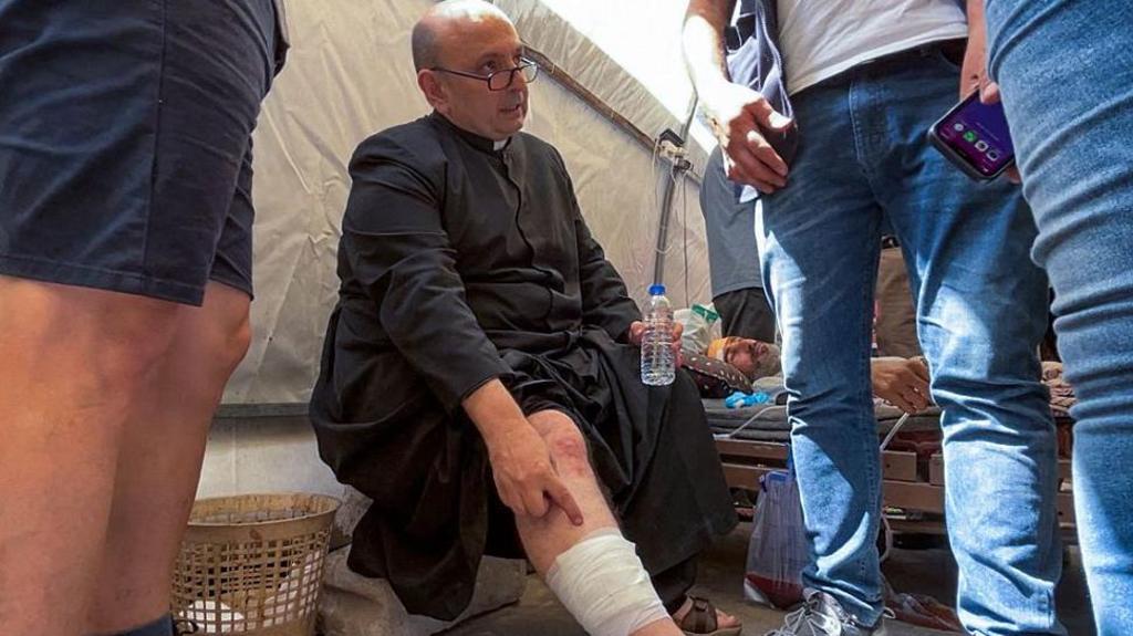 El sacerdote Gabriel Romanelli tras resultar "levemente herido en una pierna" en un ataque atribuido a Israel