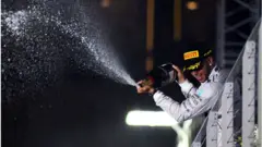 Hamilton sprejar segerchampagne på supportrarna