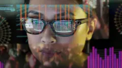 Close up stock photo of a girl studying moving data on her computer screen