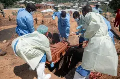 Amatsinda y’abakozi ba Croix-Rouge na Croissant-Rouge barimo gushyira mu mva isanduku y’imfubyi ya kane yishwe na Ebola, imfubyi yo mu kigo cy’imfubyi cy’i Bunia,  aha bayishyiraga mu irimbi rya Mbiyo, mu mujyi wa Bunia, mu ntara ya Ituri, muri Repubulika ya Demokarasi ya Congo. Ifoto yo ku itariki ya 19 Kamena (6) mu mwaka wa 2026.