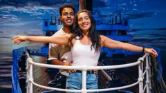 ثنائي - شاب وفتاة - يقلدان وضعية الممثلان ليوناردو دي كابريو وكيت ونسليت في مقدمة السفينة في فيلم "تايتانيك"