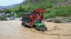 خیبر پښتونخوا کې یو لارۍ موټر د سېلاب له منځه تېرېږي
