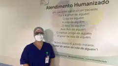Psicóloga com equipamentos de proteção posa em hospital