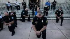 Policías de Coral Gables arrodillados
