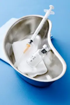 Imagem de um recipiente com uma seringa e um vidro