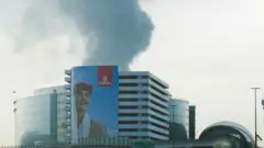 16 मार्च 2026 को दुबई हवाई अड्डे के पास के उठता हुआ धुआँ.यह धुआँ एक ड्रोन हमले में ईंधन टैंक के क्षतिग्रस्त होने के बाद उठा है. 