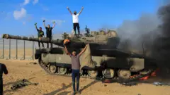 شبان فلسطينيين يحتفلون بعد السيطرة على دبابة إسرائيلية