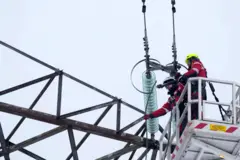 Рабочий перерезает провод