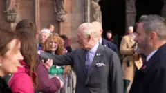 A picture of King Charles greeting fans outside a cathedral