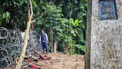 Una persona al lado de los alambres en el Darién