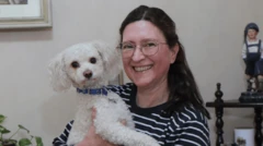 Retrato de Mónica Astorga sonriendo y sosteniendo a su perrito en su casa de Buenos Aires.