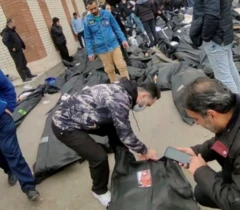 テヘランの病院の庭には黒い遺体袋があり、その親戚と思われる人々が遺体の周りにいた。彼らはそれが自分の親戚であるかどうかを確認している。