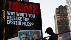 Плакат с надписью "Трамп, почему бы тебе не обнародовать дело Эпштейна" на стене здания