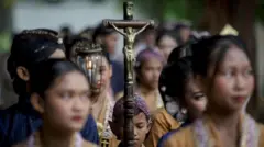 परंपरागत जावानीज (जावा प्रांतातील) पोशाख परिधान केलेले कॅथलिक श्रद्धाळू ख्रिसमस मासाच्या मिरवणुकीसाठी तयारी करत आहेत. 