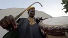 Adebayo ariko avyura umuco w'ingoma za Nigeria.