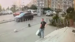 Umugabo wambaye ipantalo y'ikoboyi n'umupira wijimye w'amaboko magufi afite ishashi n'igikapu kijyamo ibintu binyuranye, abitwaye mu kuboko kumwe, arimo kugenda ava mu nyubako, yerekeza ahaparikwa imodoka, i Kyiv, muri Ukraine.