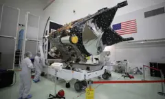 Equipe da Nasa olha um objeto que vai ser usado para o estudo