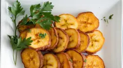 Vue du dessus, tranches de plantain frites avec du persil frais