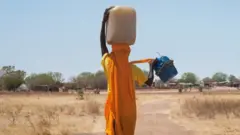 Sudanese woman carrying water