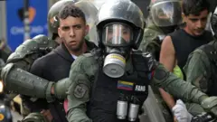 Dos jóvenes detenidos a principios de agosto son llevados por agentes de la Guardia Nacional de Venezuela