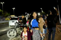  24 Haziran 2026'da Venezuela'nın Caracas kentinde, bir kadın depremin ardından çocuklarla birlikte yürüyor.
