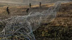 Soldados ucranianos instalam arames e outras defesas contra tanques