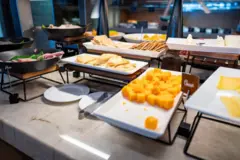 Imagem de queijos e biscoitos em uma mesa de buffet