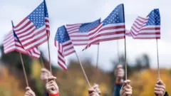 People raising American flags in the air