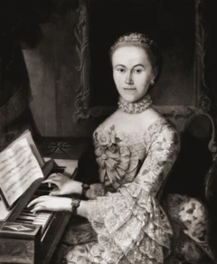 Nannerl, vestida com um vestido de renda, está sentada tocando piano com as duas mãos.