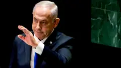 Benjamin Netanyahu, Israel's prime minister wit white inner, blue tie and black suit wit im hand stretched out