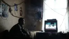 Житель Макеевки смотрит телевизор (2018 год)