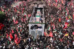 Pipo dey throway flowers on top of Khamenei coffin as e dey make im public procession for di Iran capital of Tehran