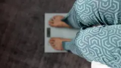 Pernas de uma pessoa que está sobre uma balança