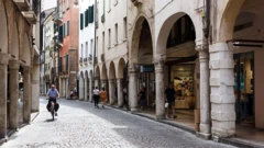 Pessoas andam em rua de paralelepípedo em Treviso