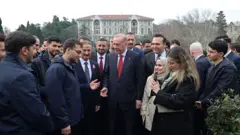 Cumhurbaşkanı Erdoğan yanında çok sayıda genç ve arkasında korumalarıyla birlikte Boğaziçi Üniversitesi kampüsünün bahçesinde. Arkada okulun binalarından biri gözüküyor