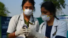 File photo showing two Indian doctors checking a thermometer