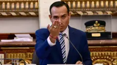 José Jerí habla a un micrófono y eleva su mano derecha.
