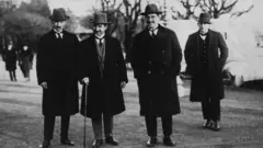 Siyah beyaz fotoğraf İsmet İnönü ve çalışma arkadaşlarını gösteriyor.