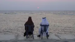 زوجی عربستانی در ساحل بندر جده. یکی از بزرگترین پایگاه‌های نیروی دریایی عربستان در این بندر قرار دارد