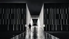 Una image en blanco y negro de un hombre con el Parlamento australiano al fondo.