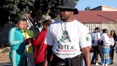 የኦፕሬሽን ዱዱላ ጽሁፍ ያለበት ነጭ ቲሸርት ያደረገ ወንድ