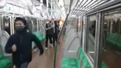 مسافران مترو در حال فرار از واگنی هستند که دود و آتش آن را فرار گرفته بود