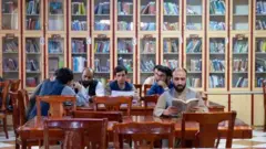Homens lêem livros em bibliotecas