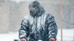 Hombre muy abrigado en plena tormenta de nieve en Nueva York, 25 de enero de 2026