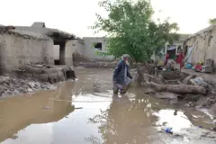 در تصویر مردی در حویلی خانه سیل‌زده‌اش دیده می‌شود. 