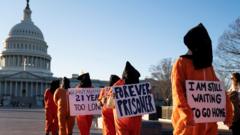 مجموعة من الأشخاص يرتدون زي السجناء يحتجون على معسكر الاعتقال في خليج جوانتانامو خارج مبنى الكابيتول الأمريكي في واشنطن العاصمة، الولايات المتحدة، 9 يناير 2023