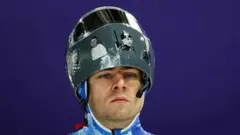 Владислав Гераскевич в шоломі з фотографіями загиблих спортсменів